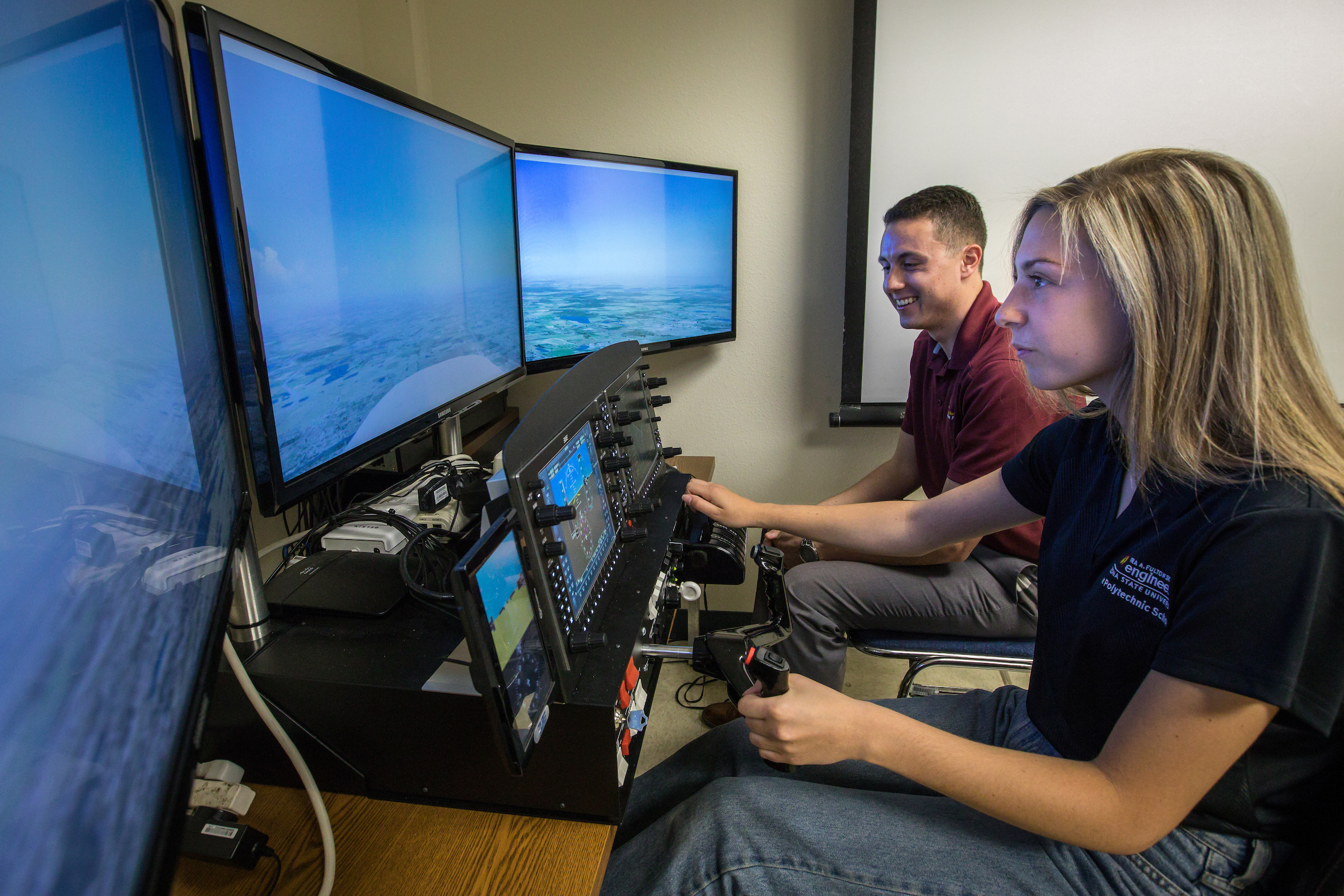 Aviation students practice with a flight simulator.