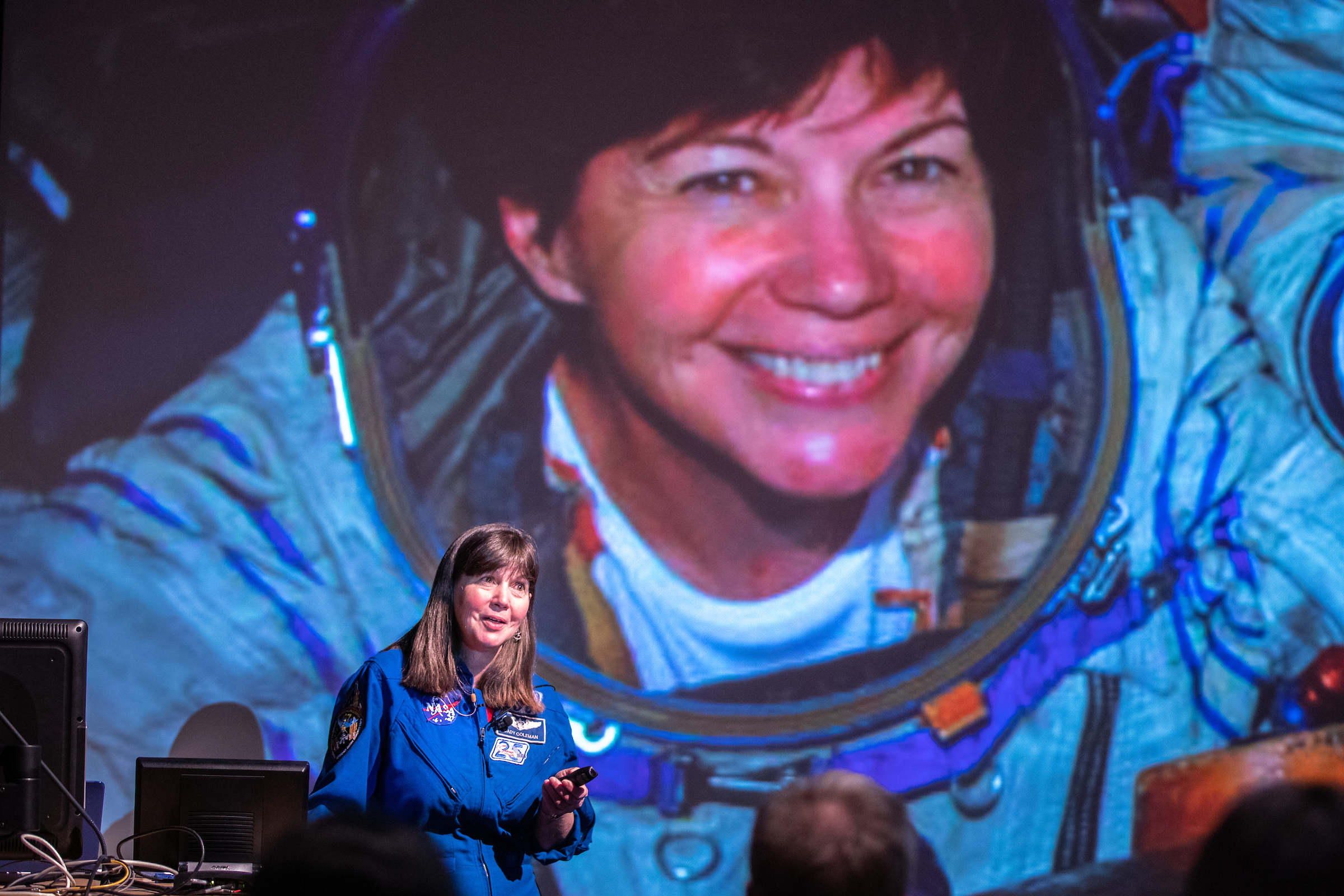 Global Explorer in Residence Cady Coleman delivers her inaugural lecture at ASU in front of a projection of a photo of her on a rocket