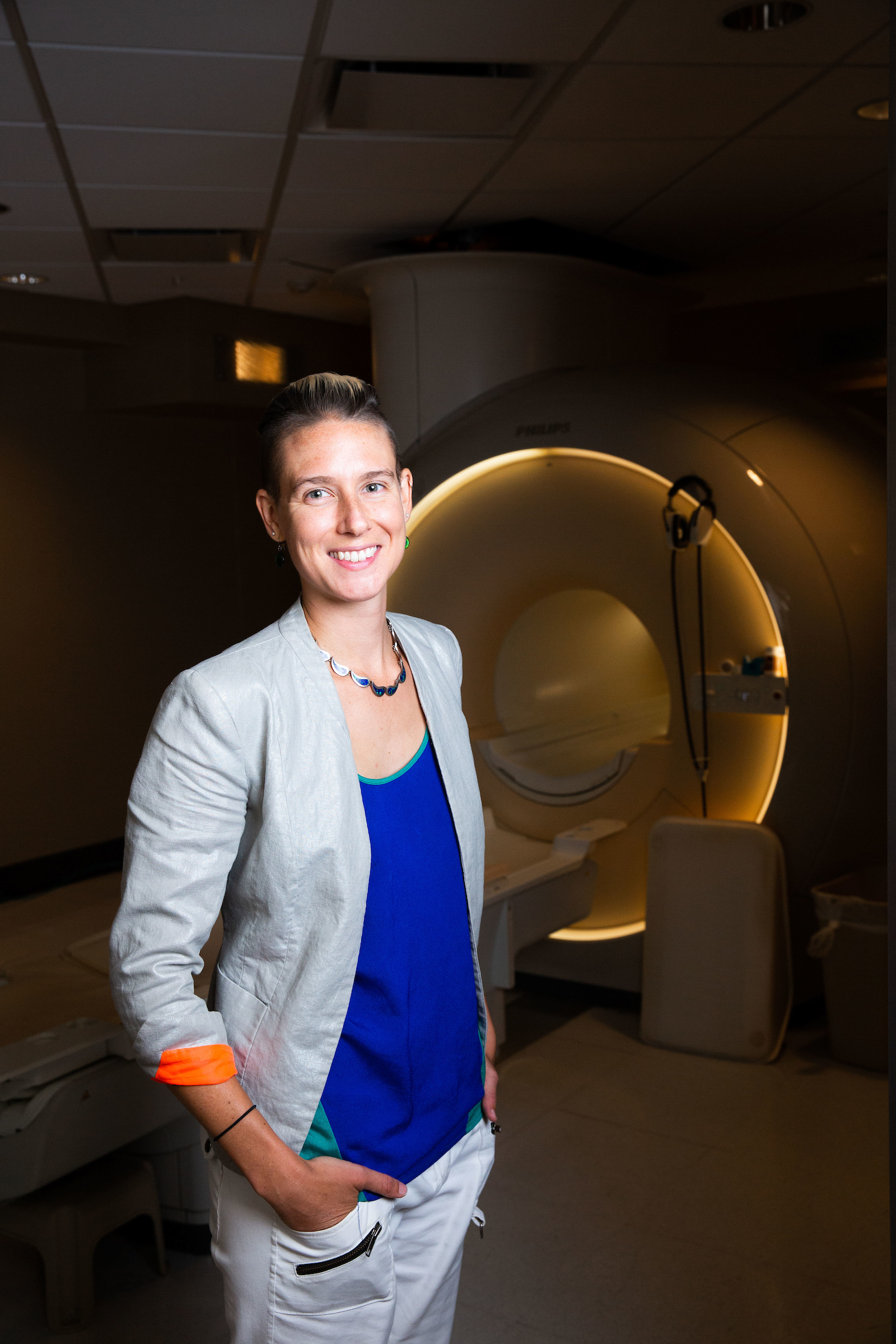 ASU College of Health Solutions Assistant Professor Blair Braden standing next to the MRI she uses in her Autism Brain Aging Laboratory research.