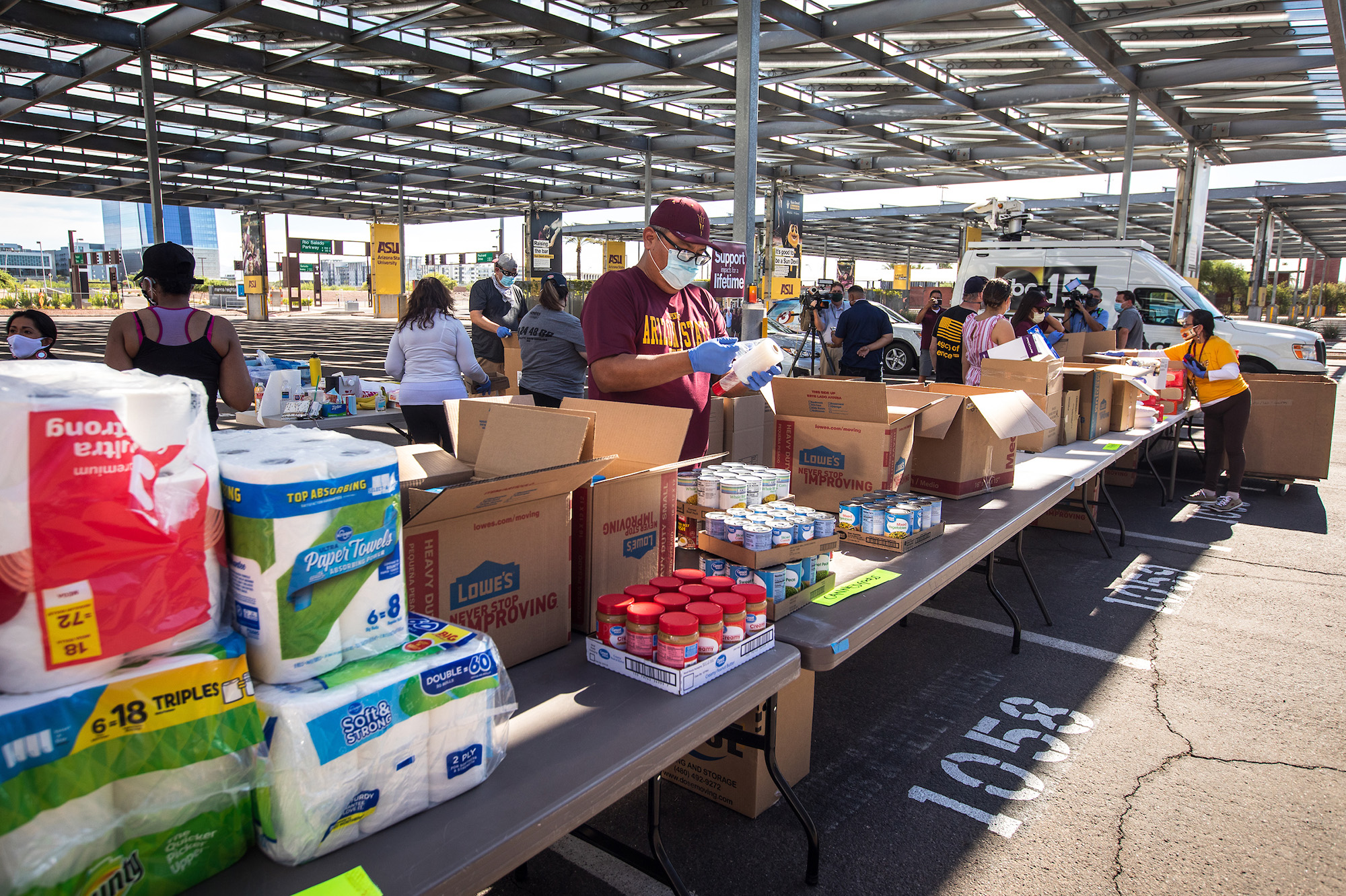 man standing at a long line of donation laden tables