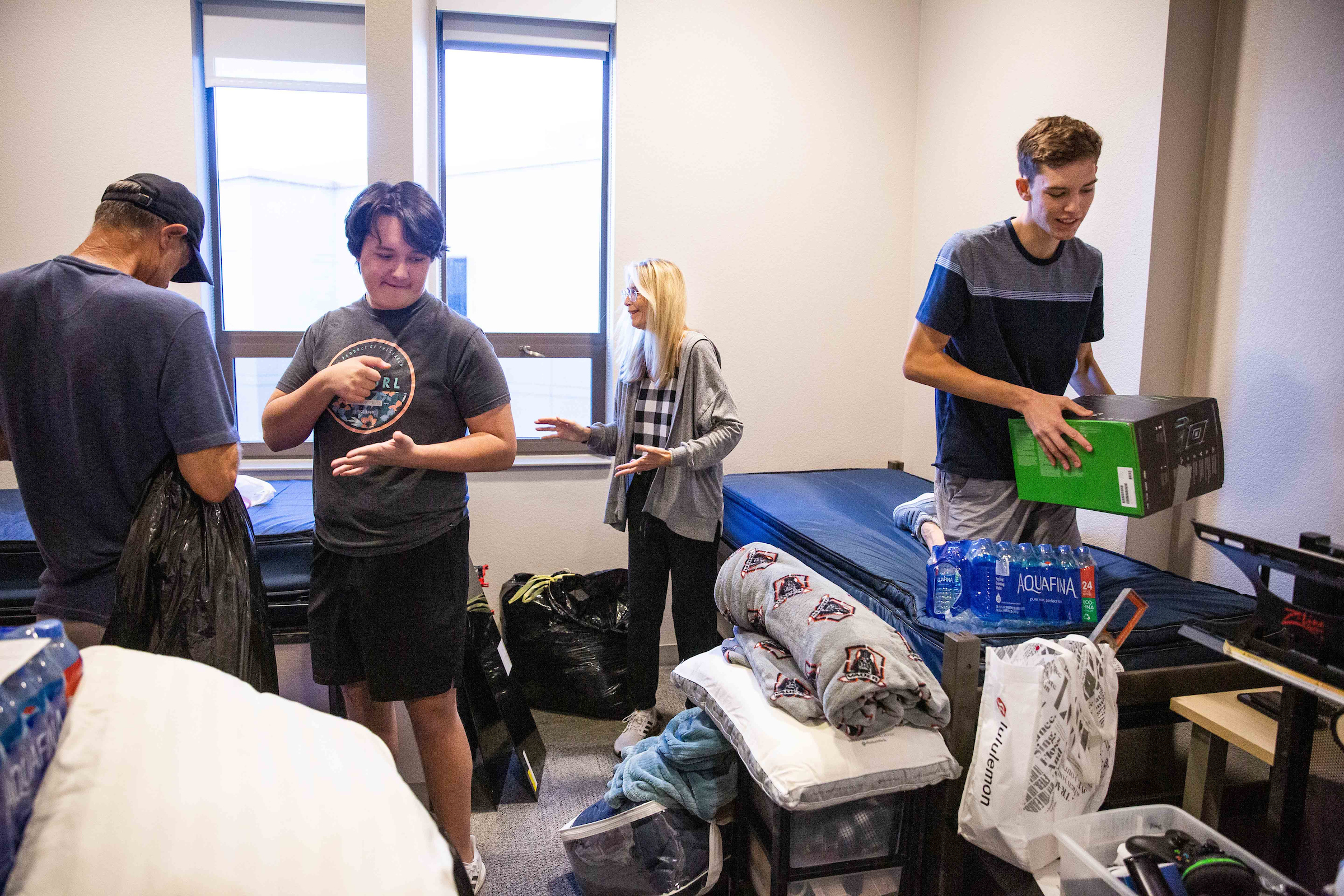 students and family unpack in dorm room