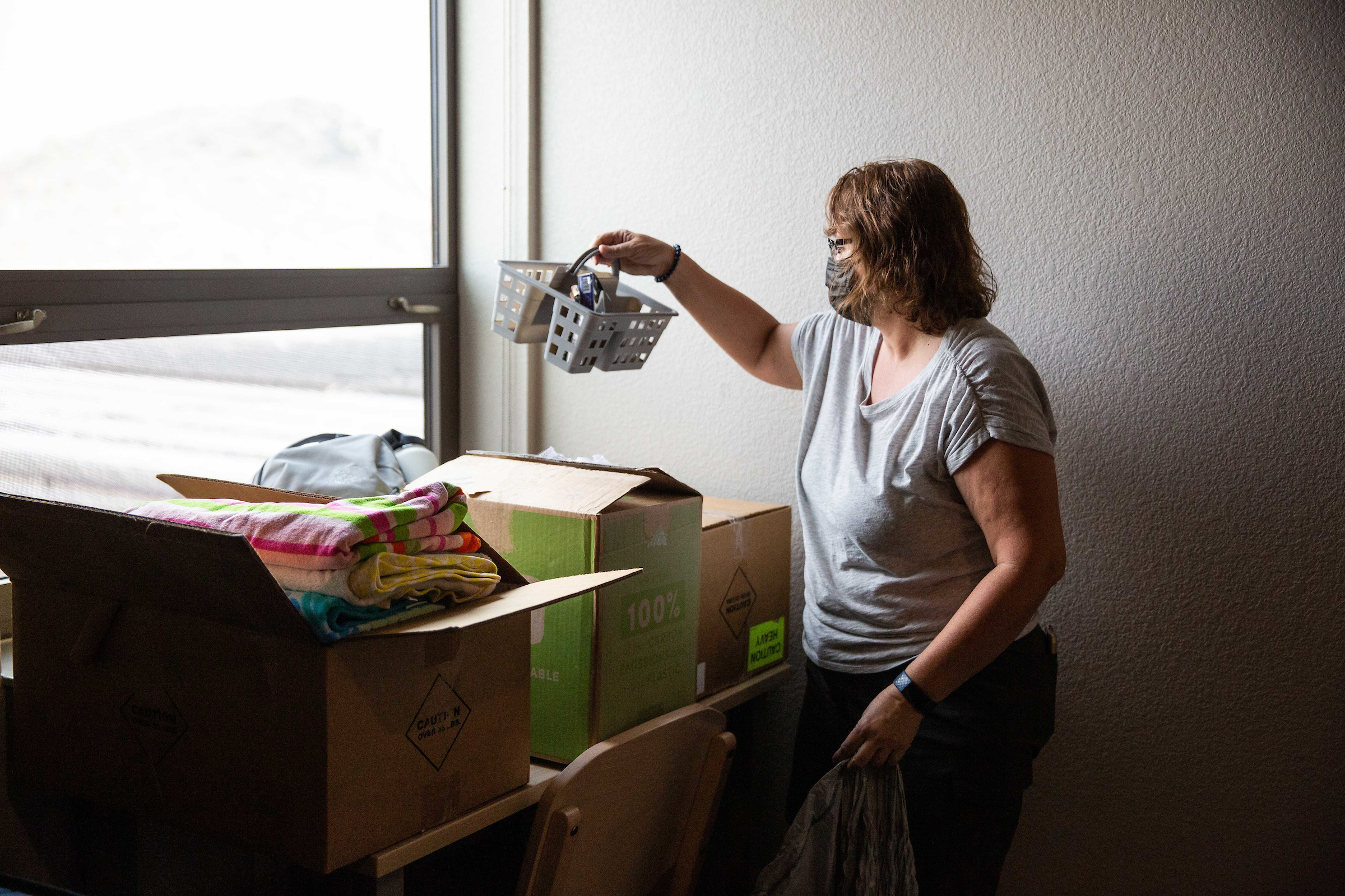 woman unpacking items in dorm room