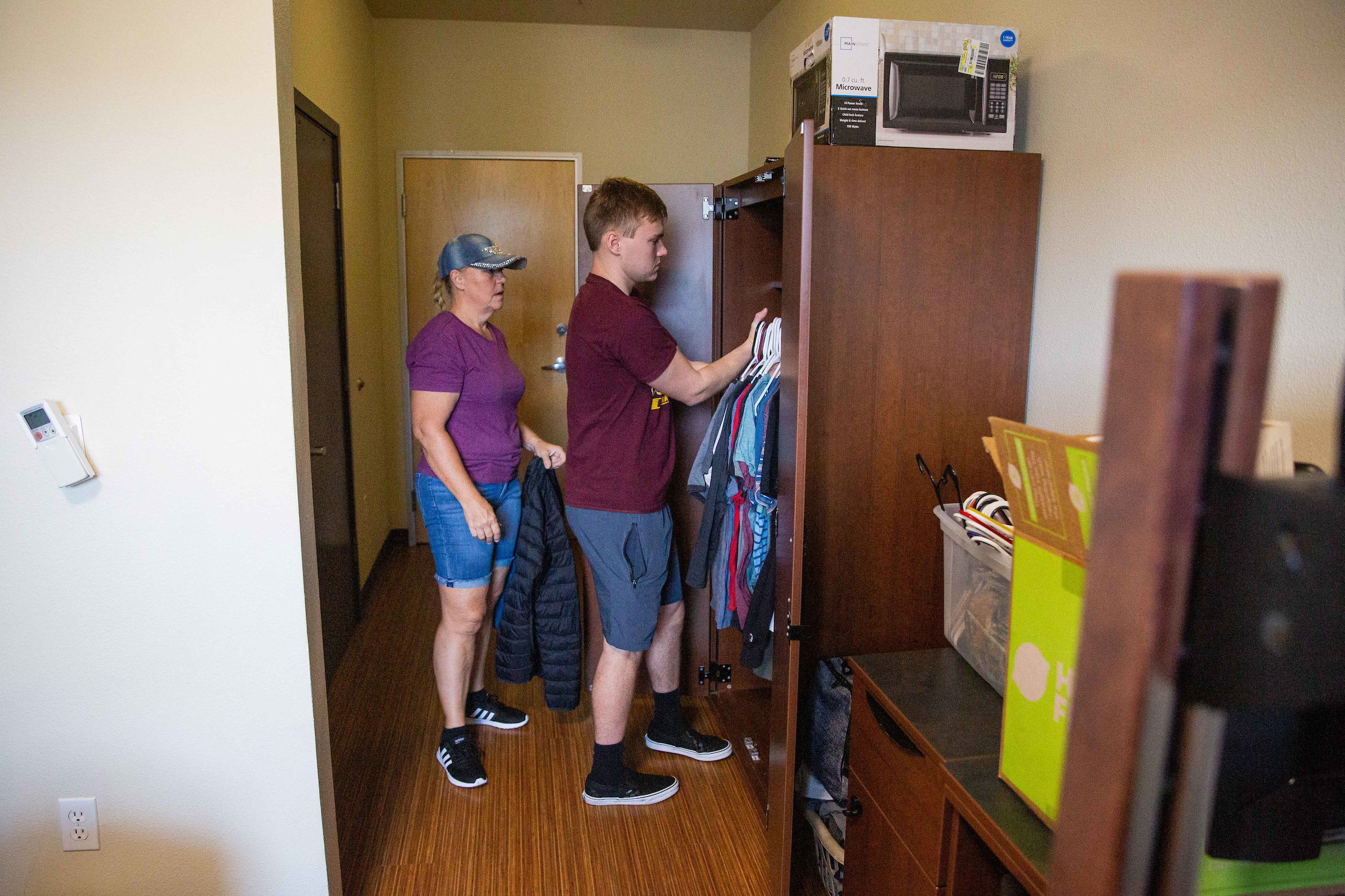mom and student unpacking dorm room