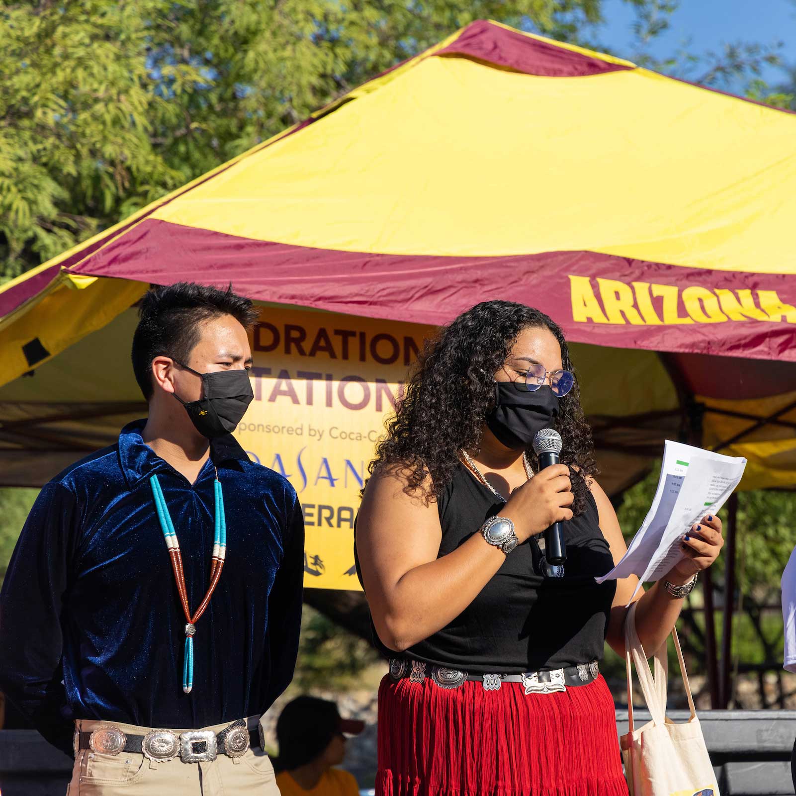 Two Native students wearing masks read a land blessing before the A Mountain hike