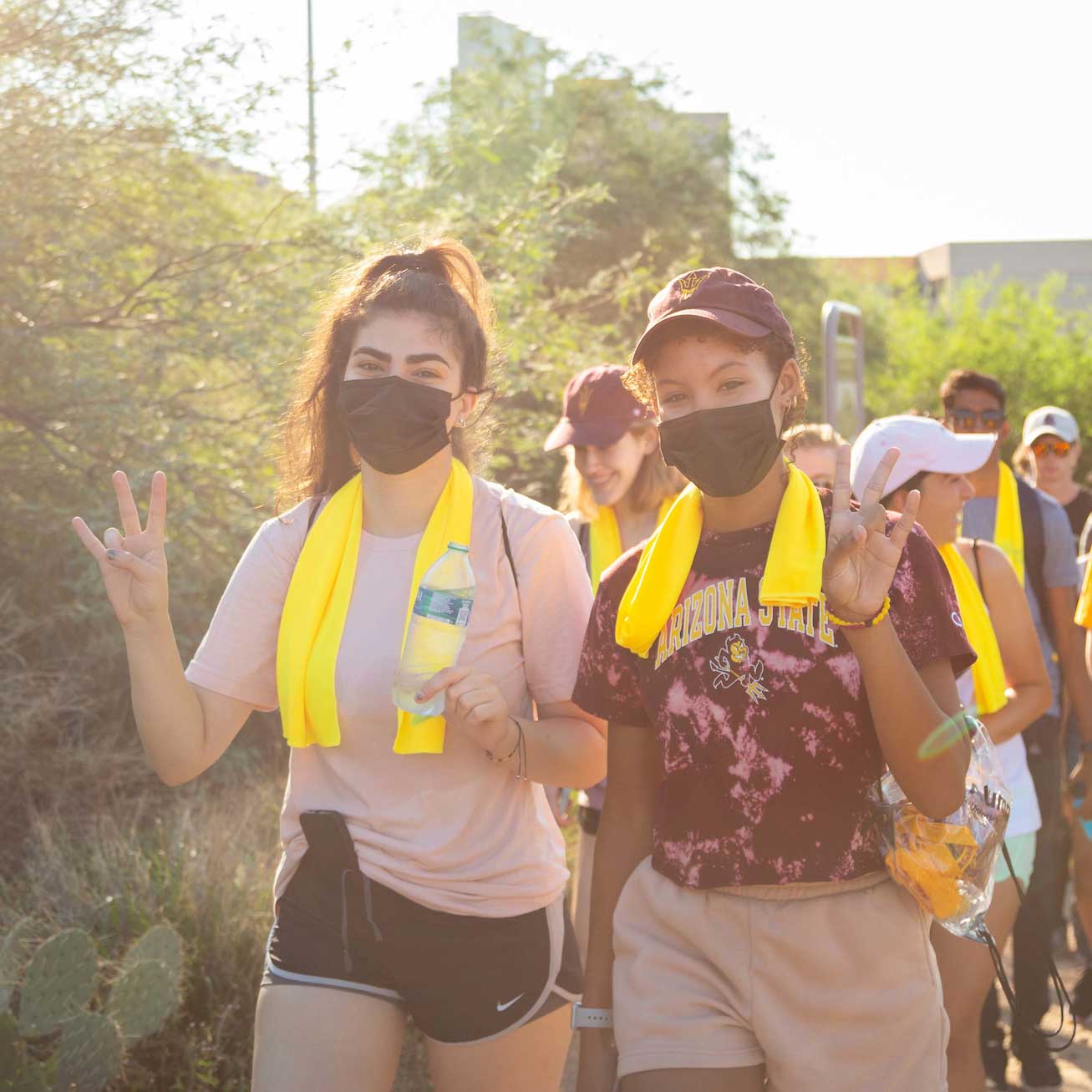 Two students wearing masks walk at the front of a line hiking up A Mountain
