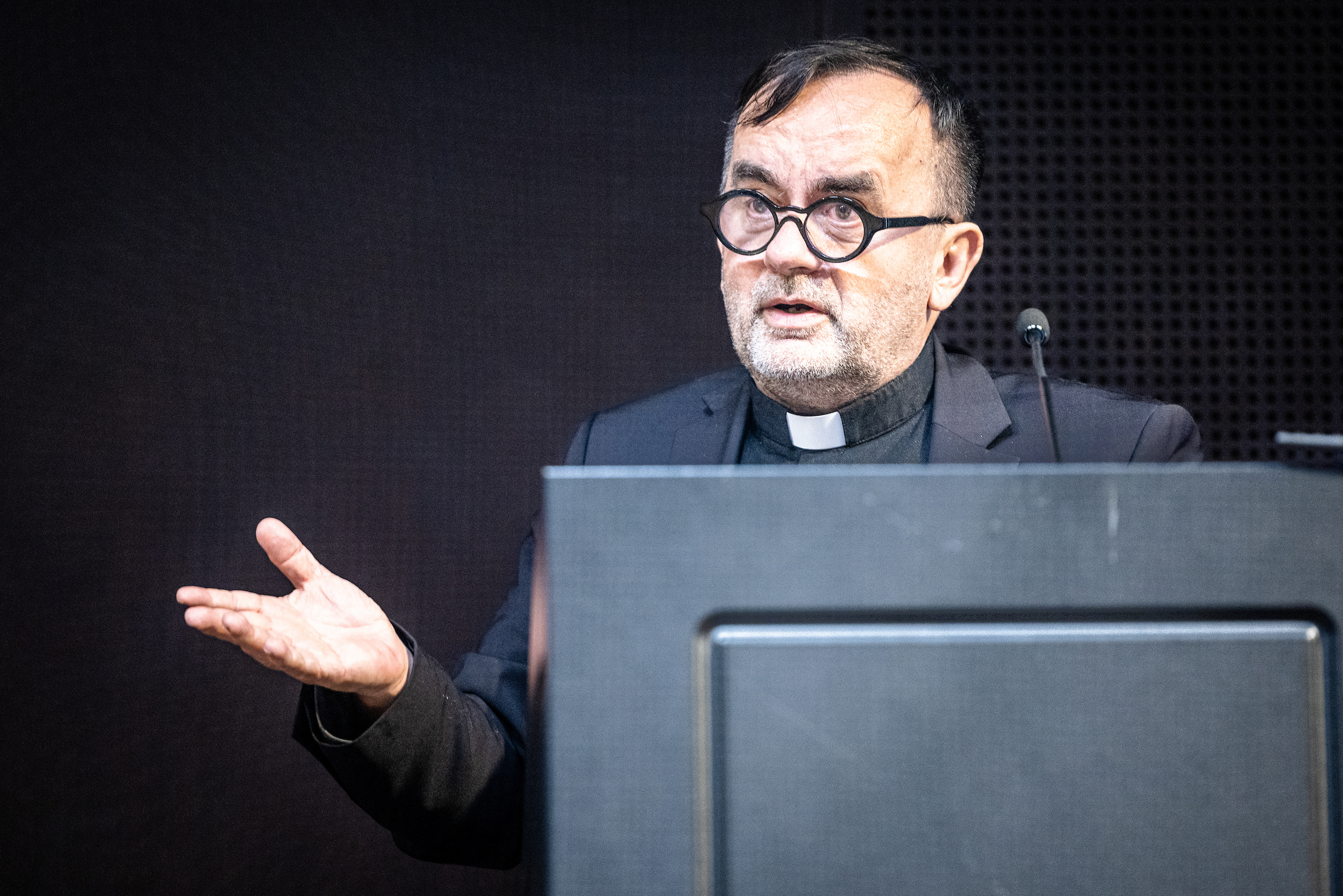 Father Patrick Desbois speaking at lectern at an event