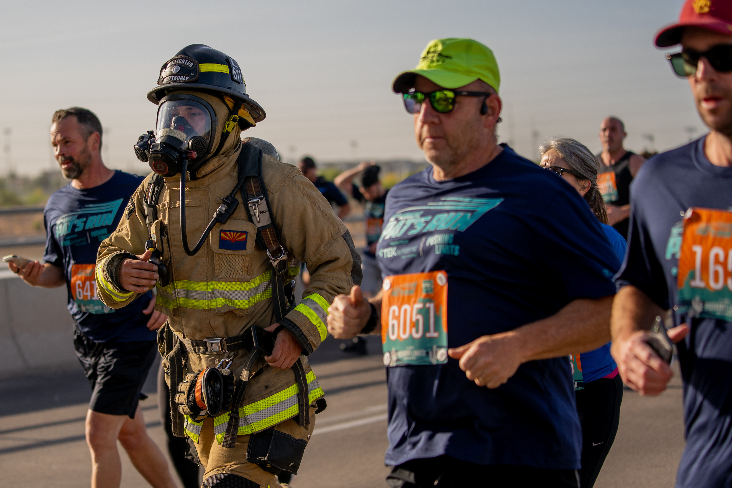 man wearing firefighter equipment run in race