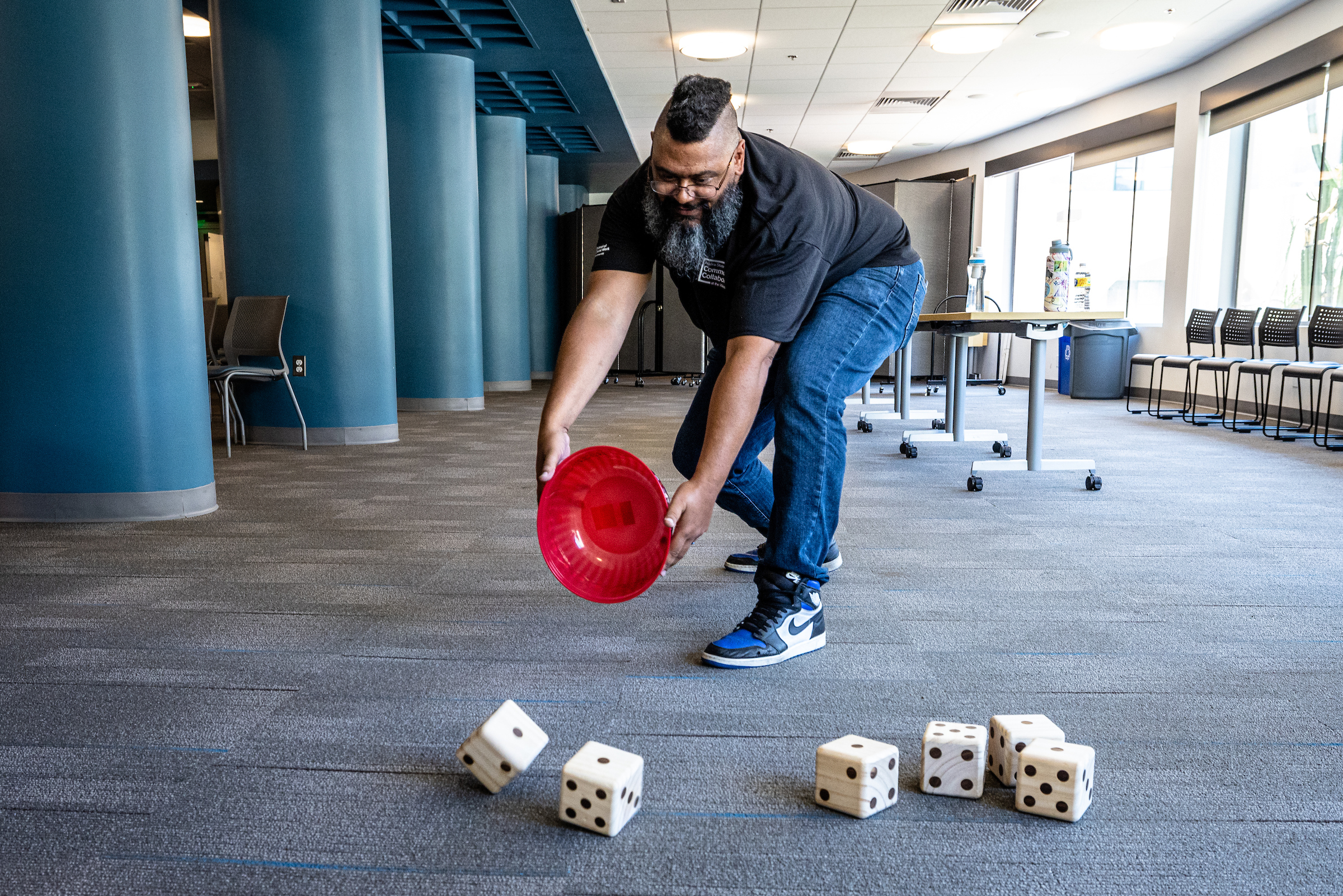 Student throws a bucket of giant dice onto the floor