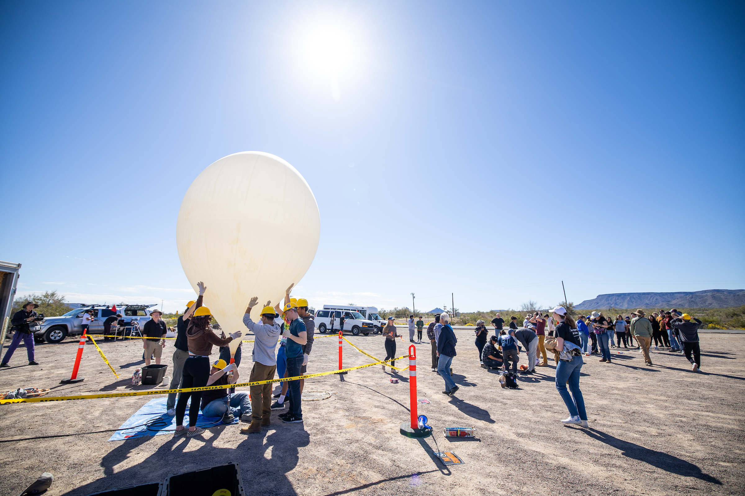 Students and volunteers prep weather balloon for a launch in the desert
