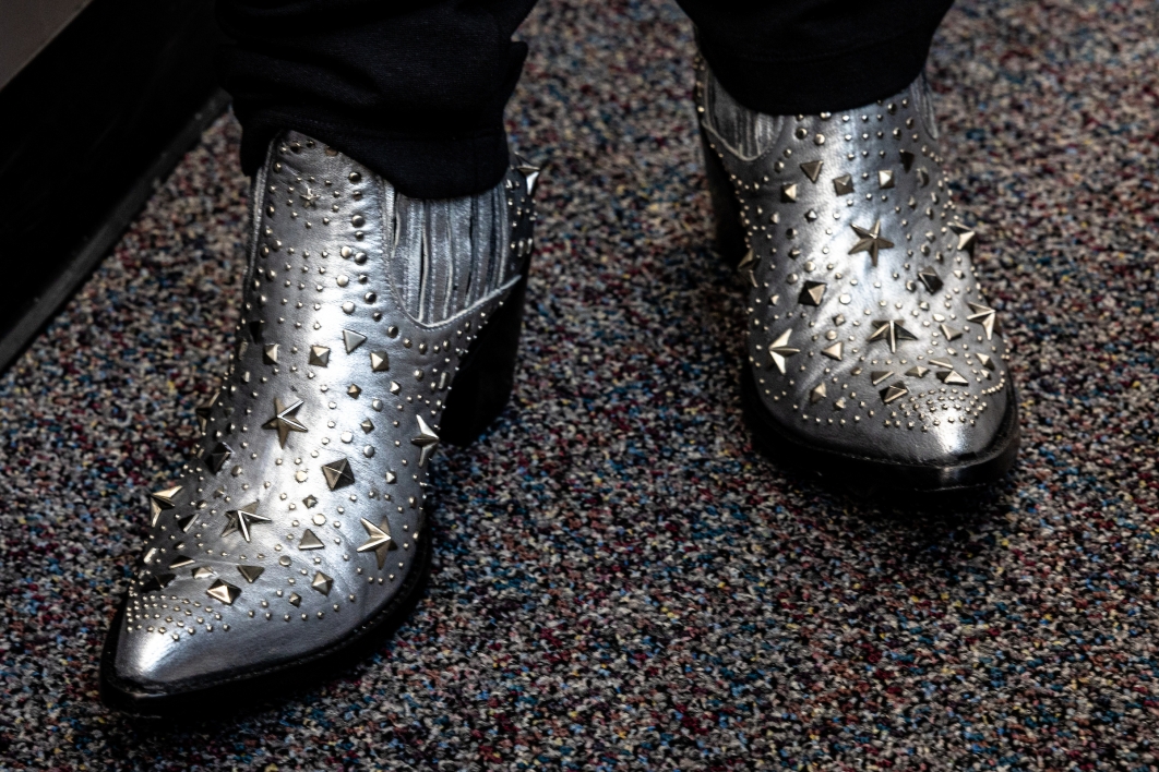 A closeup of silver cowboy boots with stars on them