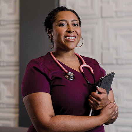 Portrait of ASU Online grad Desiree Brionne Dillard in medical scrubs