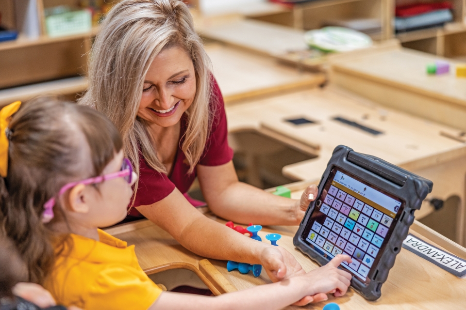 Mother interacting with child to communicate using an iPad