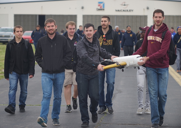 students carrying small plane