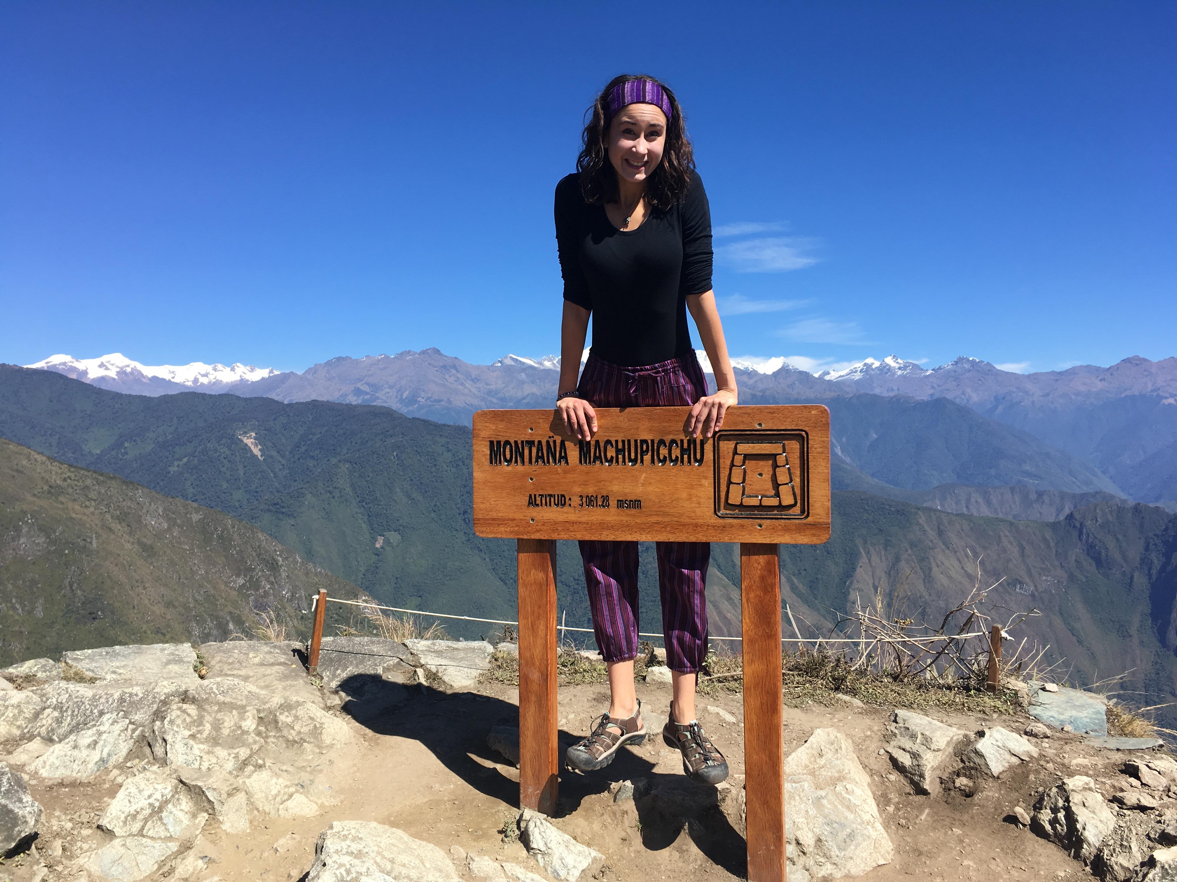 Young woman standing behind Macchu Picchu sign