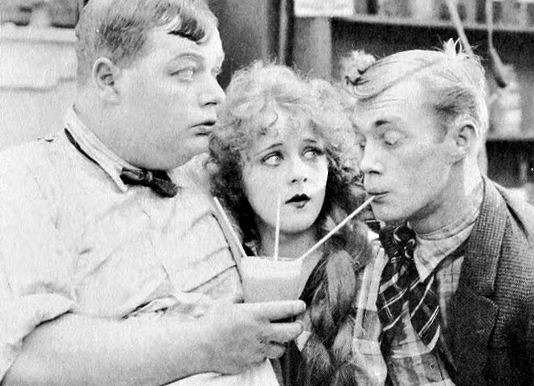 black and white photo of people sharing a milkshake