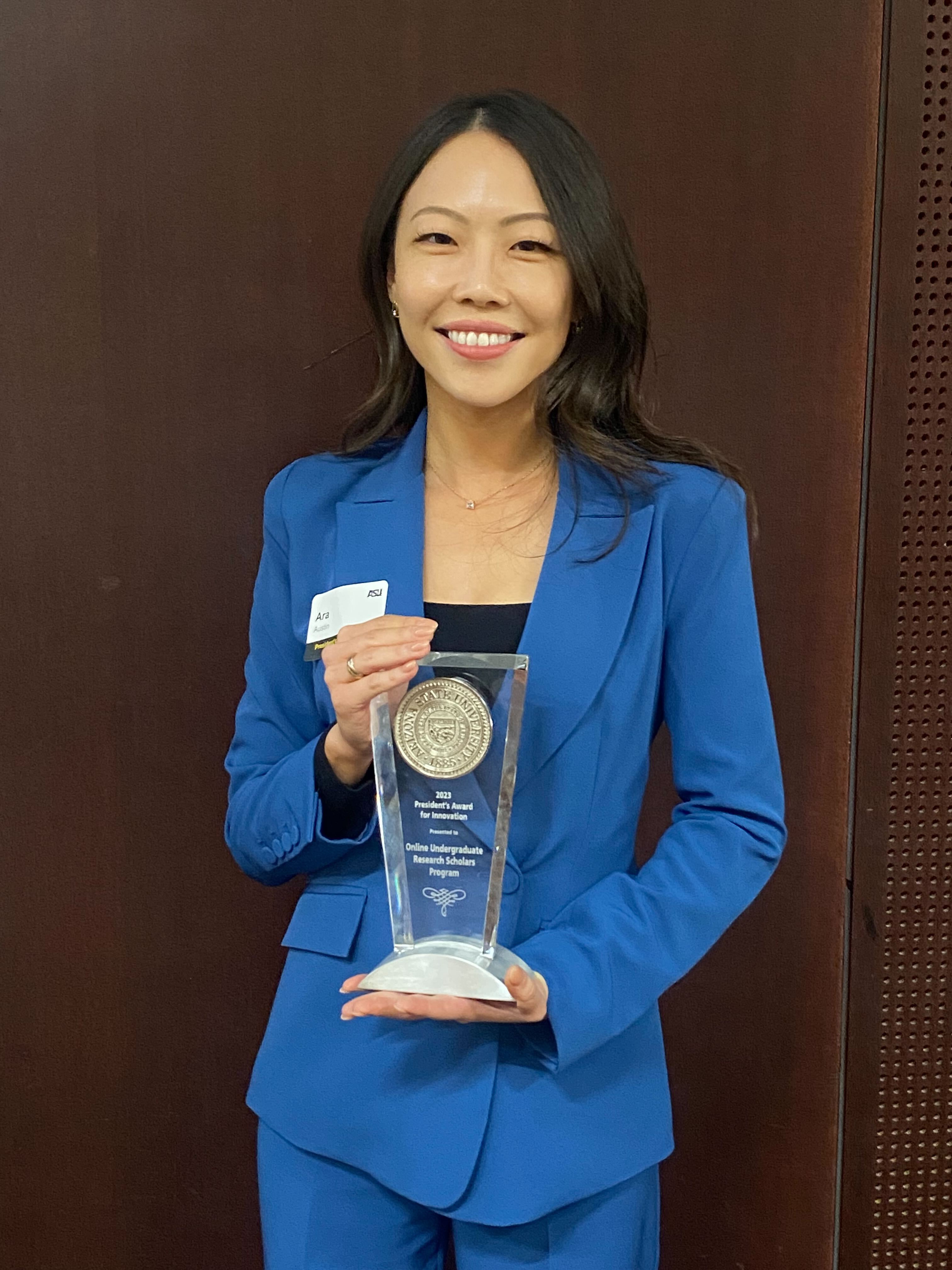 Ara Austin holding the President's Award for Innovation.