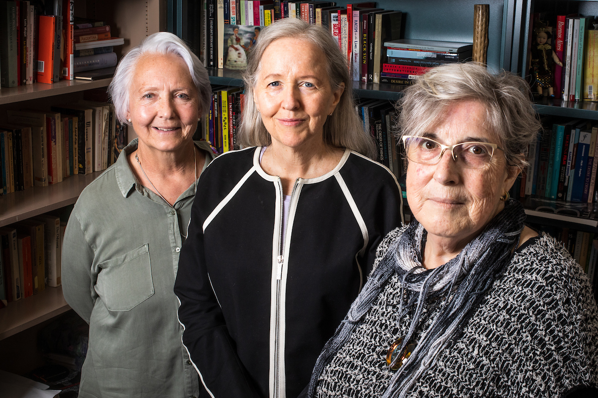 ASU Professors Cynthia Tompkins, Elizabeth Horan and Carmen Urioste-Azcorra smiling in an office with books