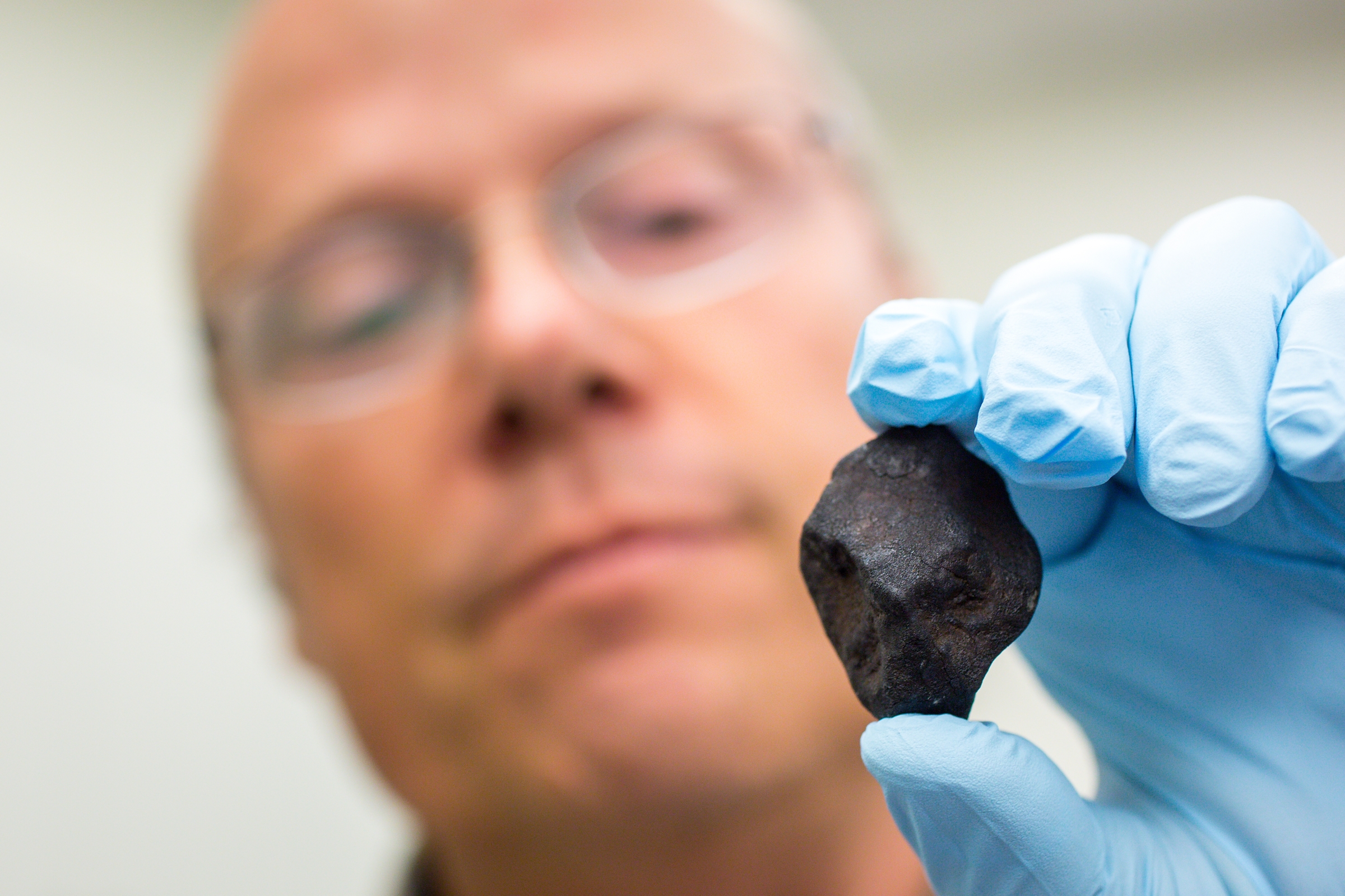 ASU research professor Laurence Garvie holds a newly found meteorite.