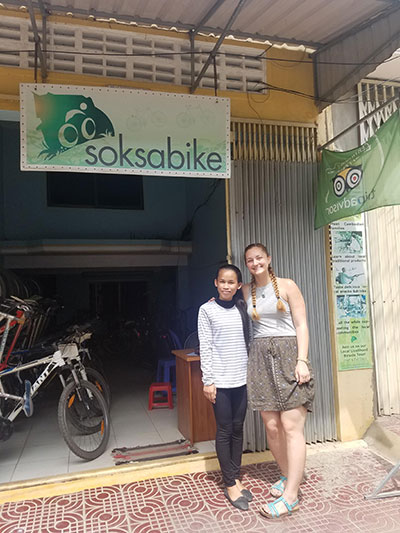 Woman and girl standing in front of a bike shop