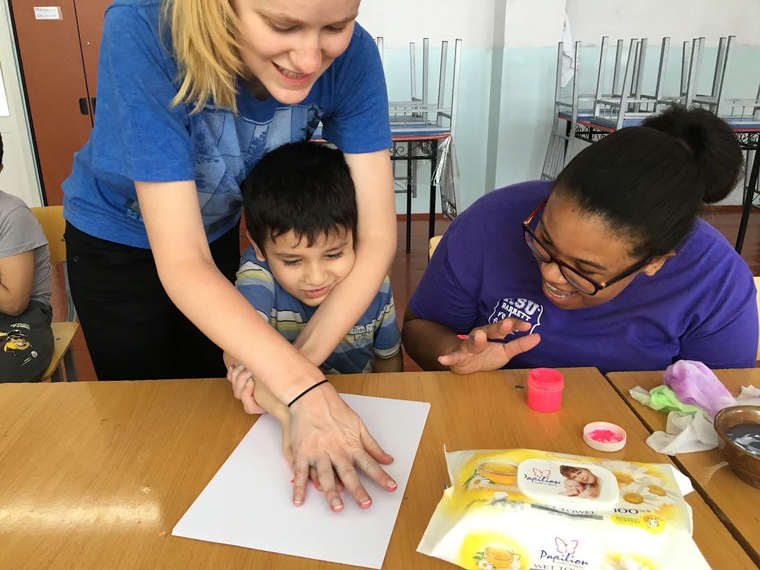 woman tracing hand prints with children