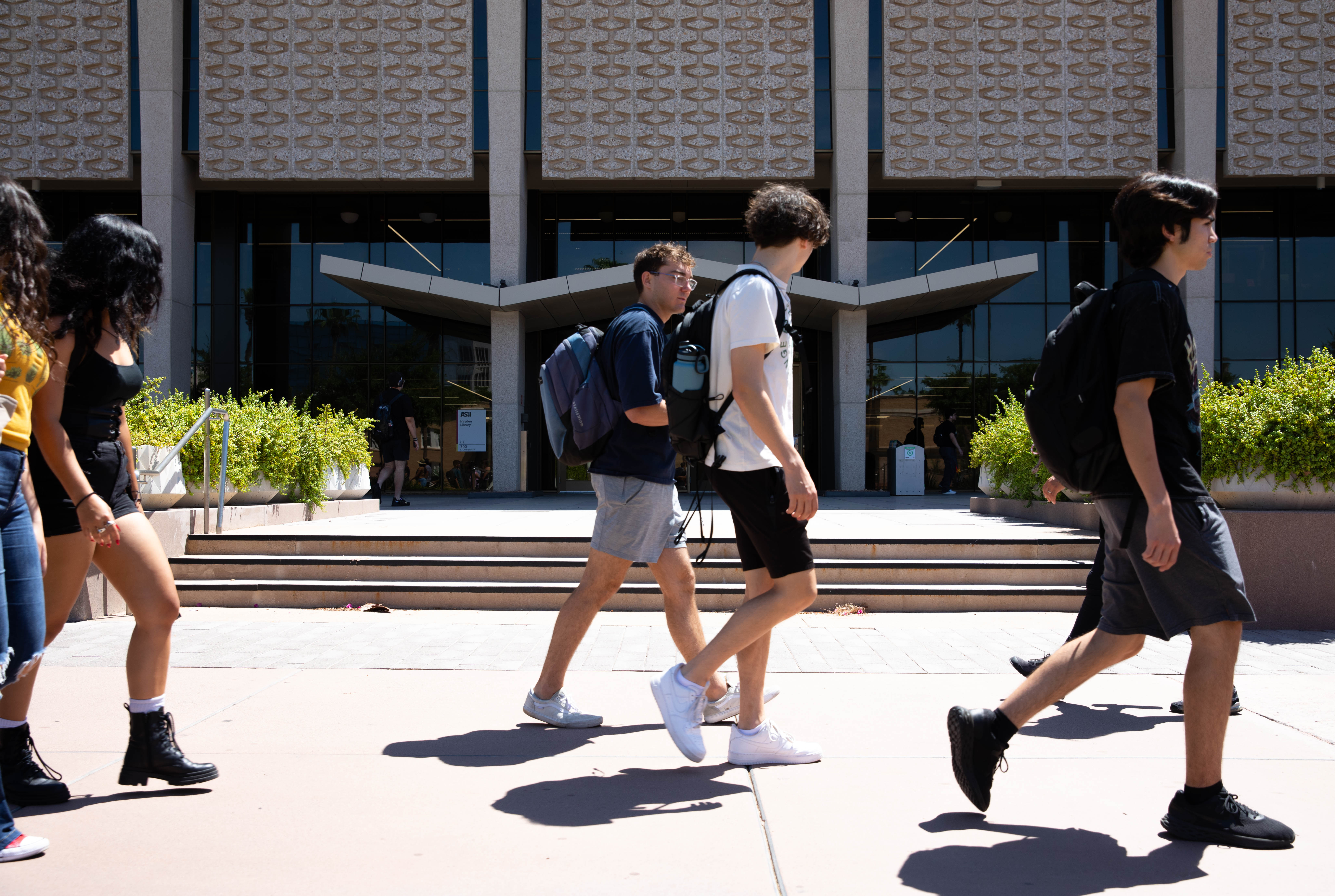 Students walk by Hayden Library on the Tempe campus.