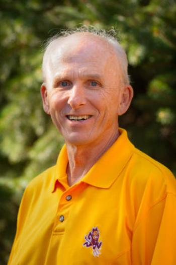 headshot of a smiling man wearing a gold polo with a Sparky the Sun Devil logo