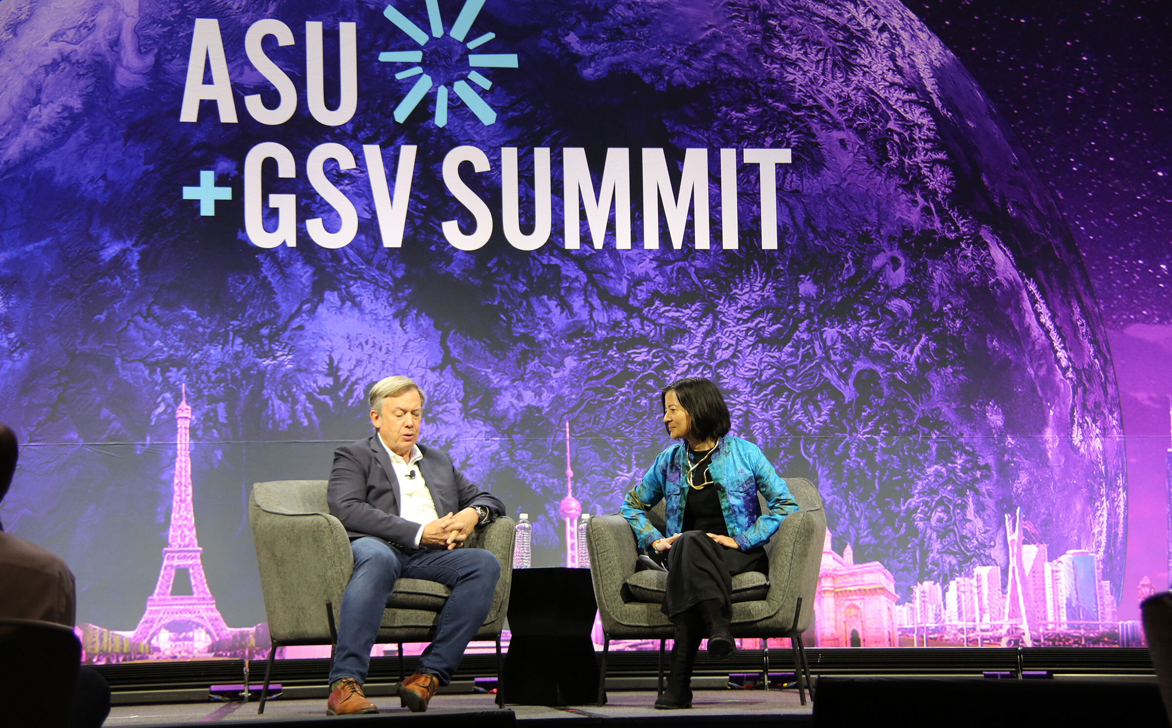 Man and woman sitting on stage talking at ASU+GSV Summit