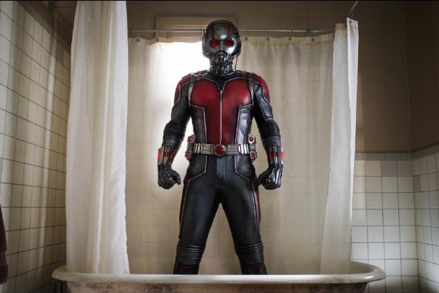 A man stands in a shower wearing the Ant-Man suit.