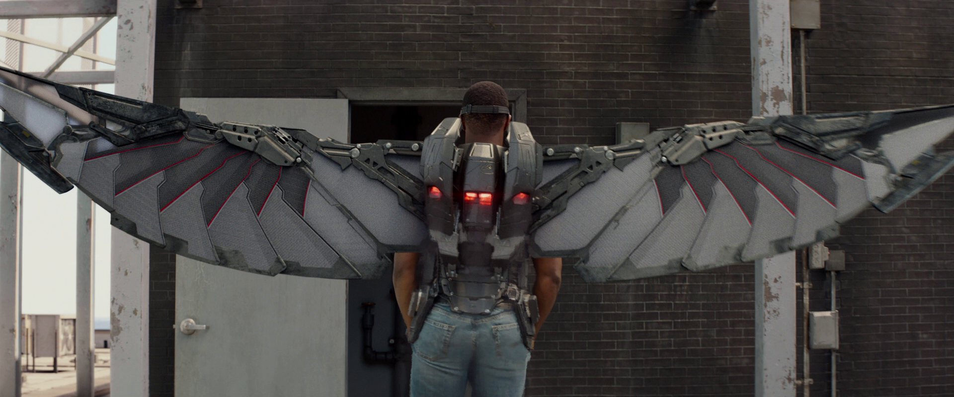 A man stands with a winged jetpack on.