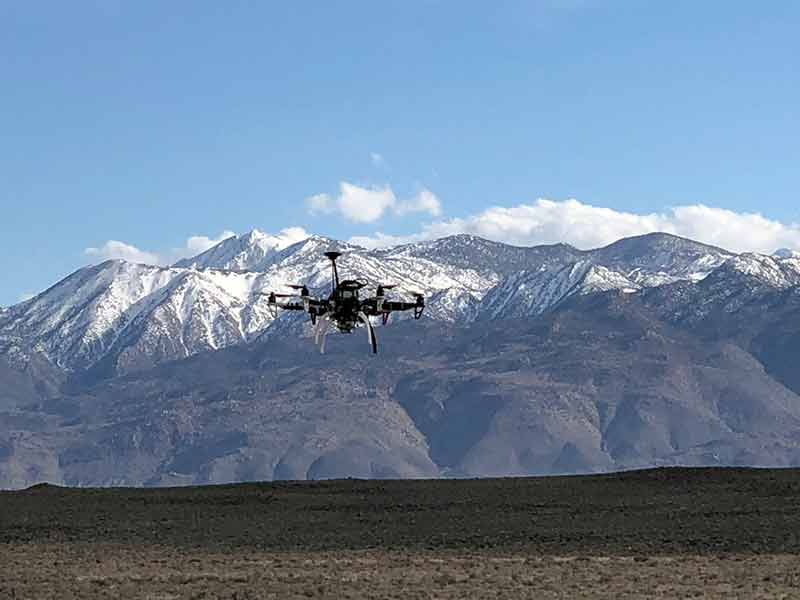 drone flying in front of desert mountains
