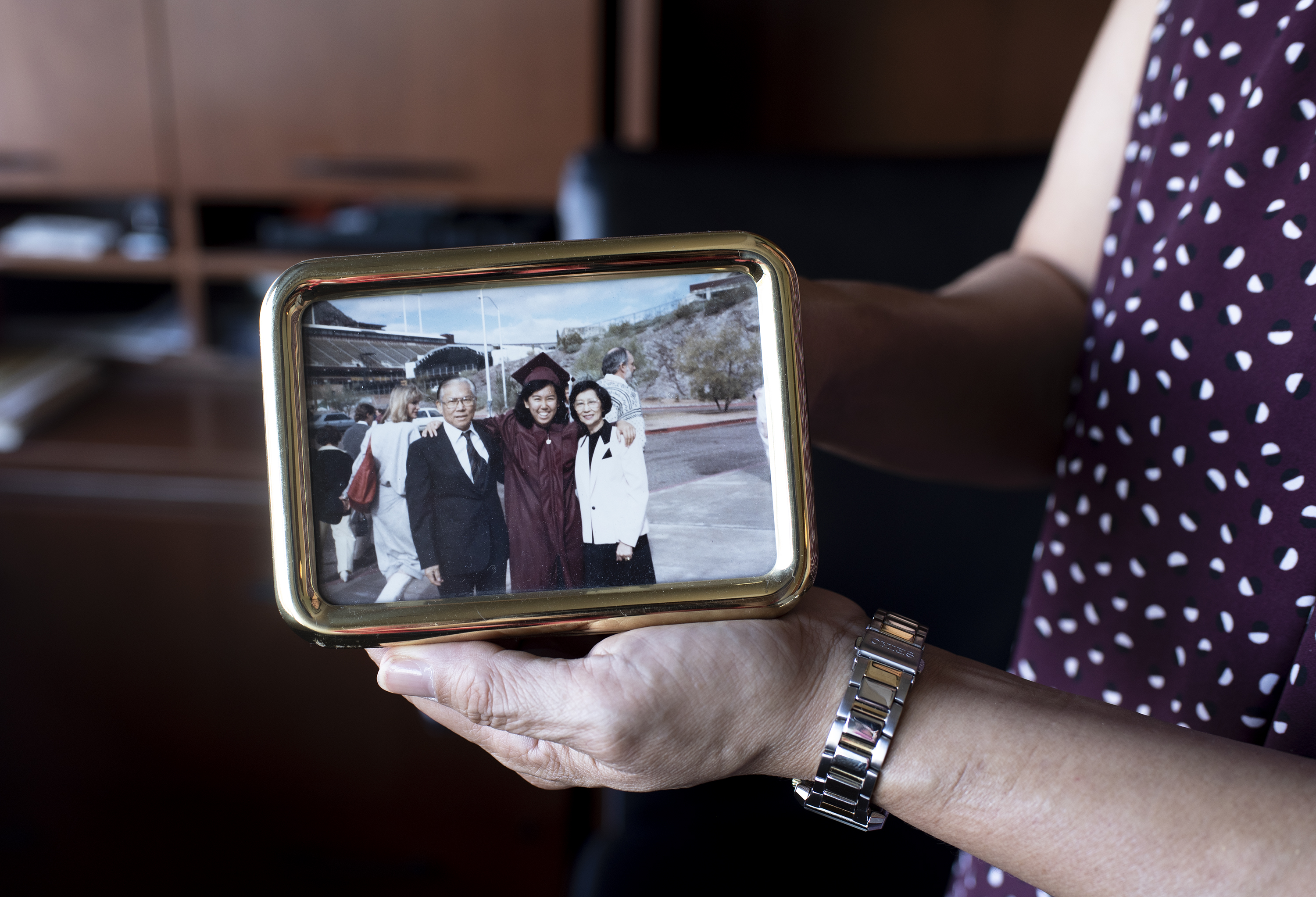 Arlene Chin shows a photo of herself and her parents, taken the day of her graduation from ASU.