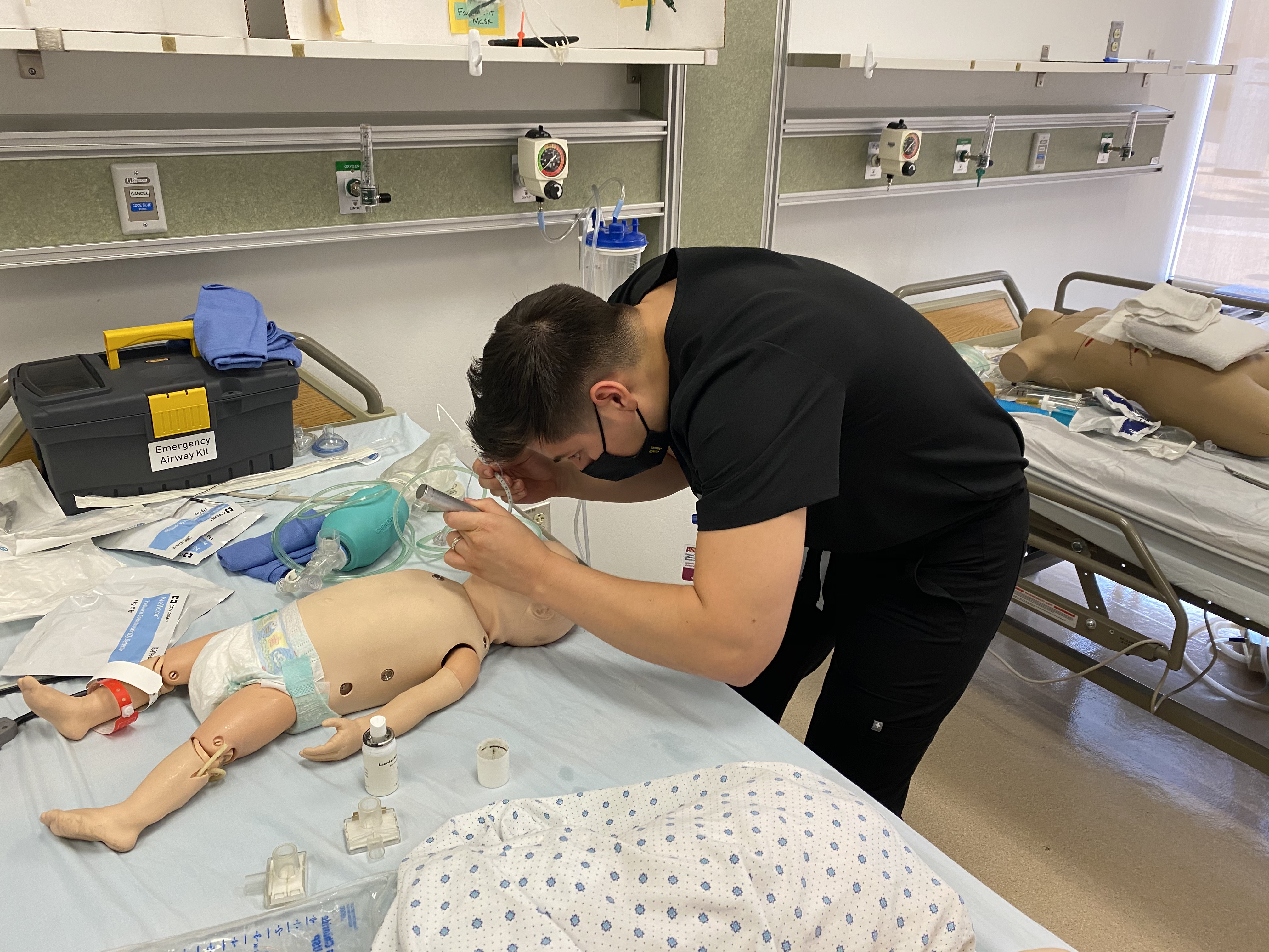 Reynaldo Kieser participates in an immersion experience, opening the airway of a pediatric patient