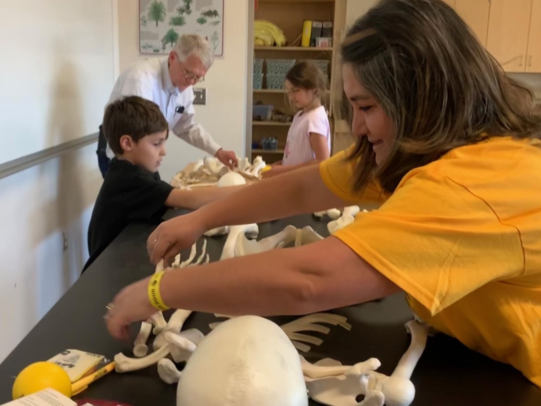 Emel Topal, her son and daughter race with College of Integrative Sciences and Arts dean Duane Roen to assemble lab skeletons at 2019 ASU Open Door event