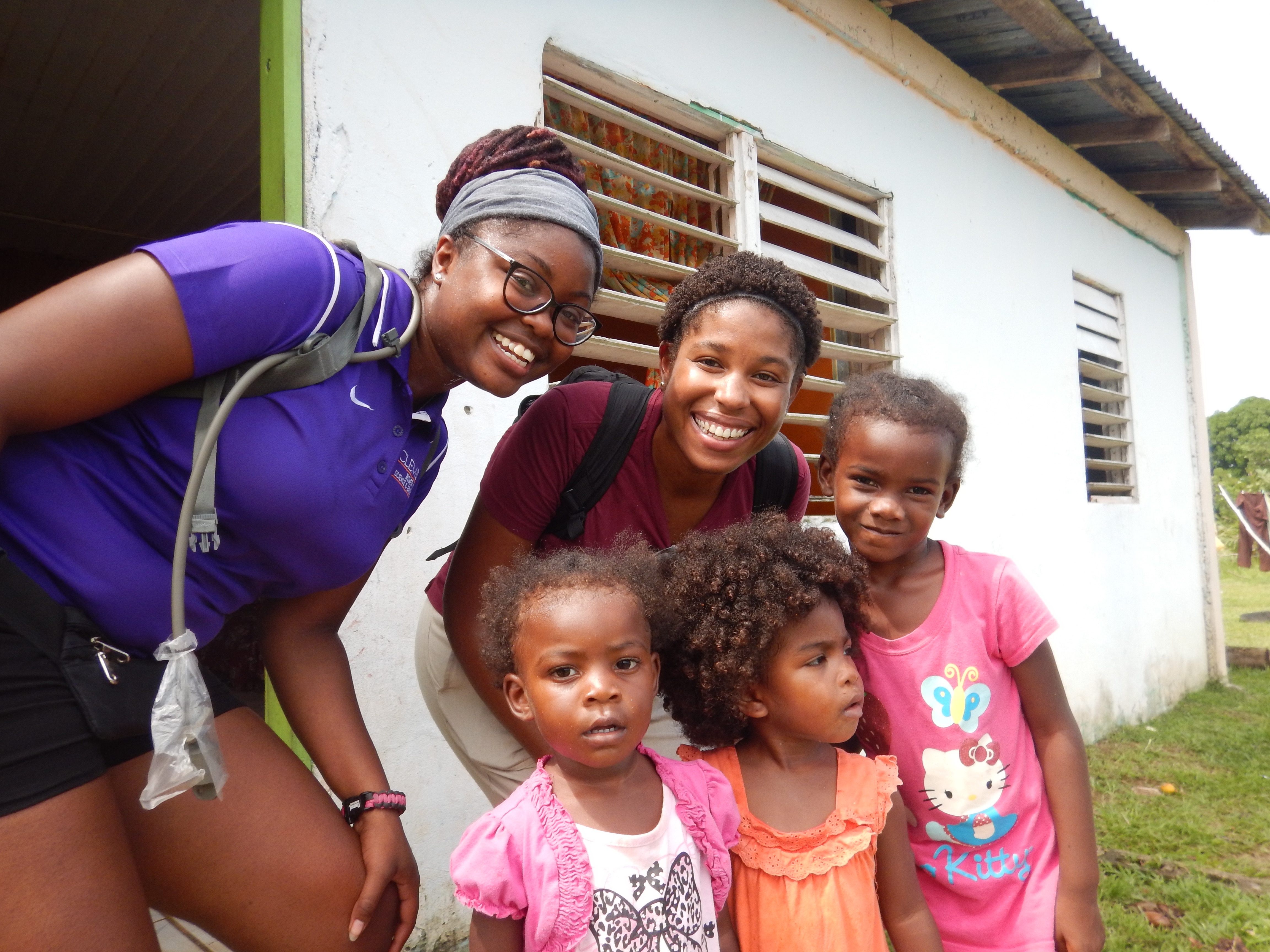 two women posing for a photo with children in Belize