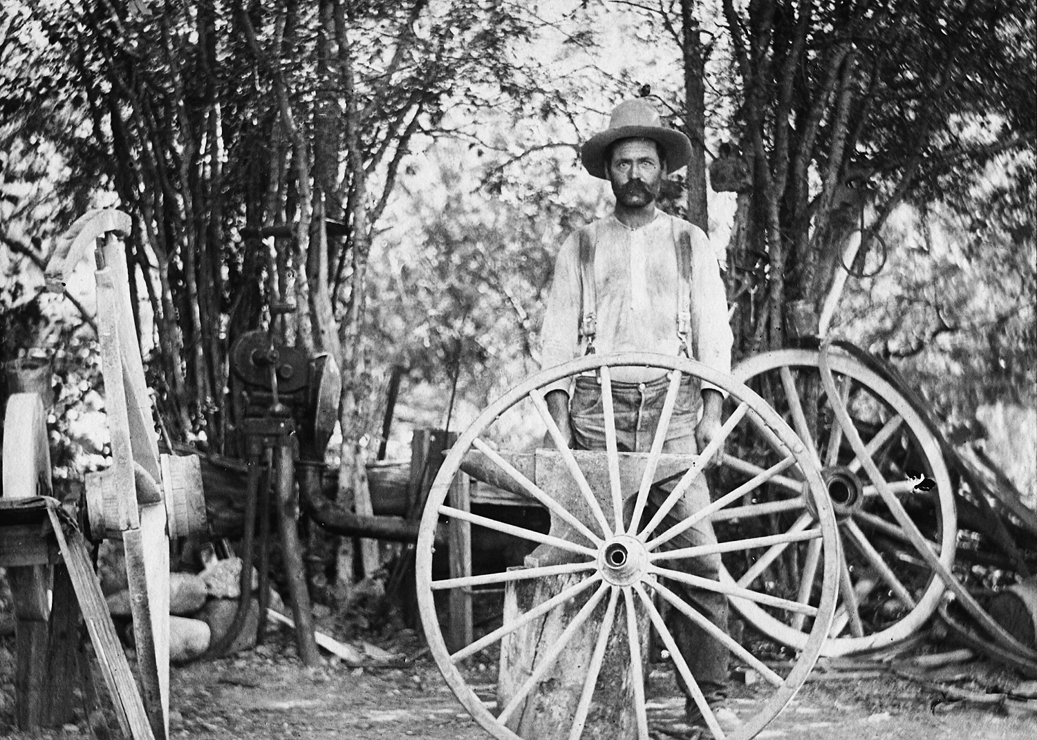 vintage photo of man behind wagon wheels