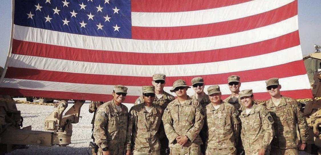 soldiers in front of an American flag
