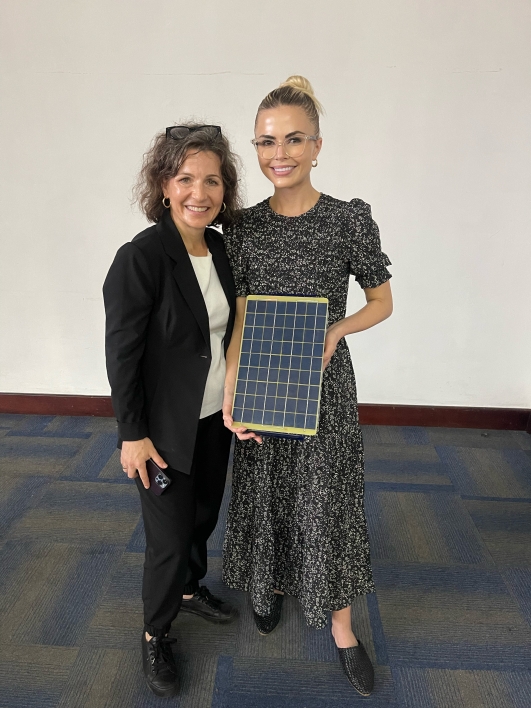 Edson College faculty member Heather Ross poses with Rachel Thompson and a SolarSPELL device in Malawi