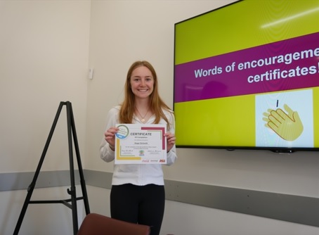ASU student Hope Schmitt smiles and holds a certificate showing completion of training for the ASU Eco Reps program.