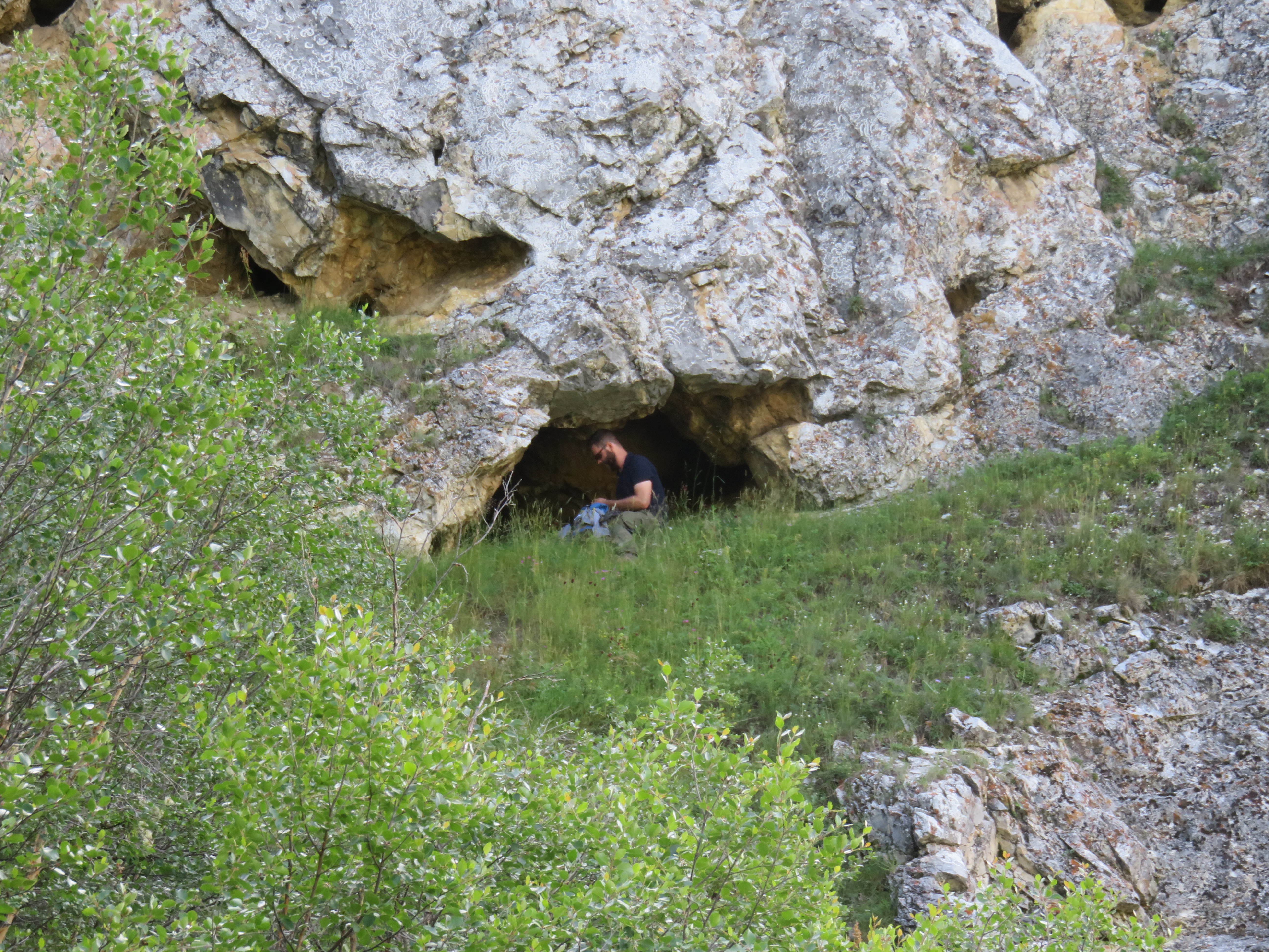 photo of Dr. Perreault exploring a rockshelter in the southern part of the Darkhad Valley.