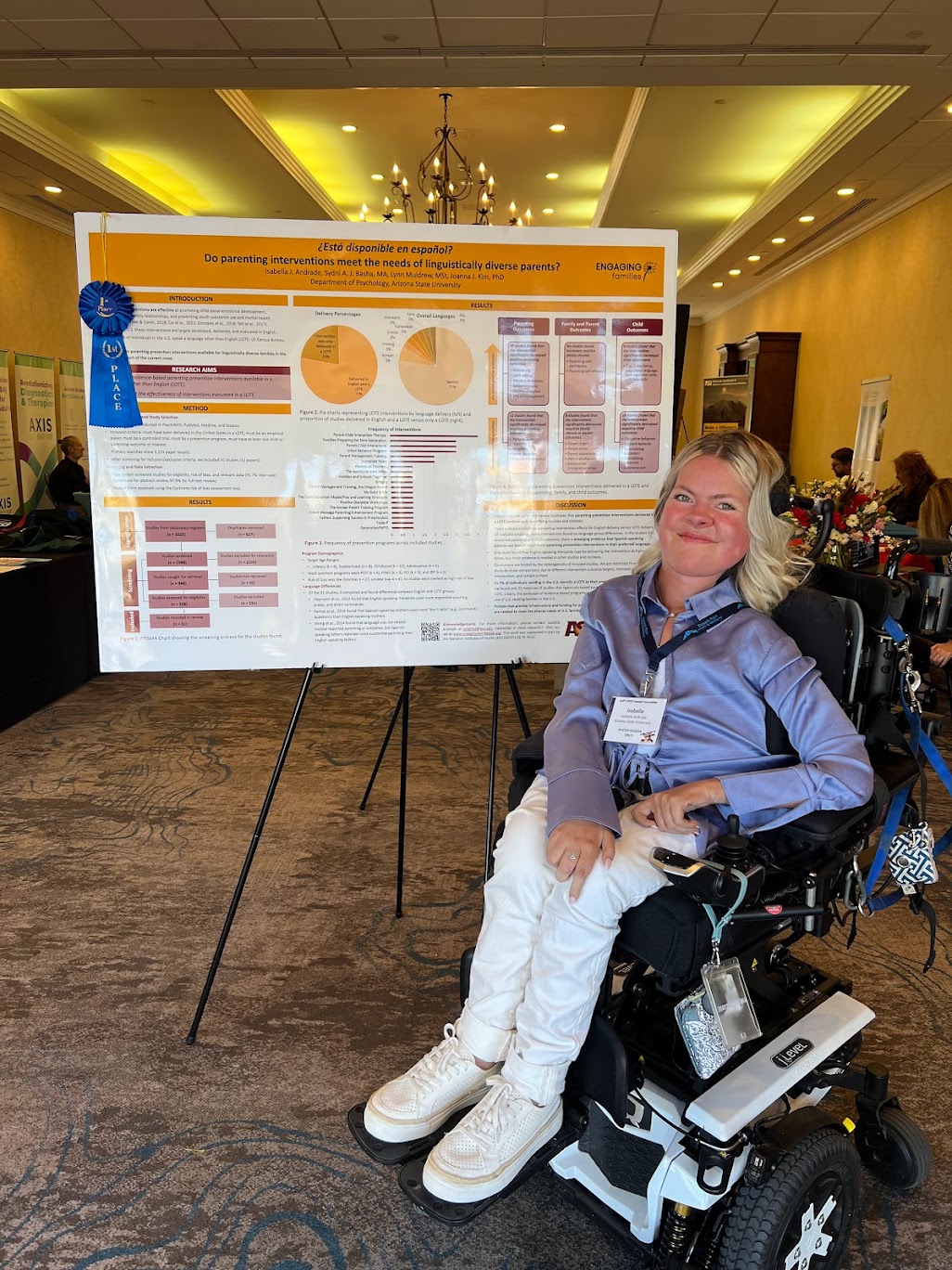 Bella Andrade poses by first-place poster showcasing results of a systematic review on programs available in the United States.