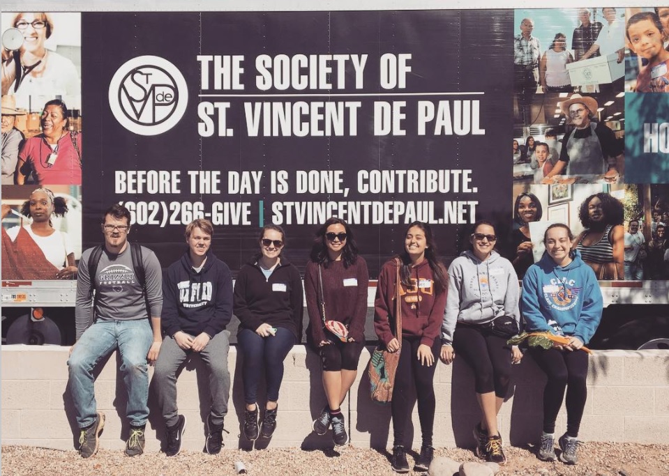 students pose in front of St. Vincent de Paul banner