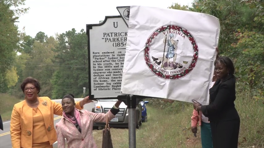 people unveiling highway marker