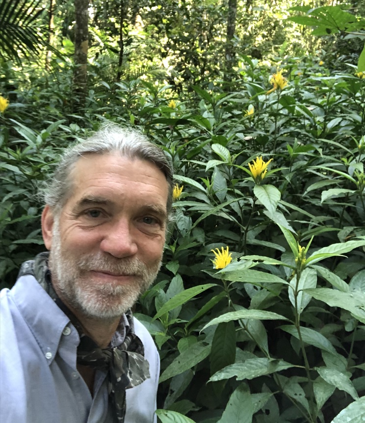 ASU Associate Professor Joel Palka in an outdoor setting surrounded by greenery.