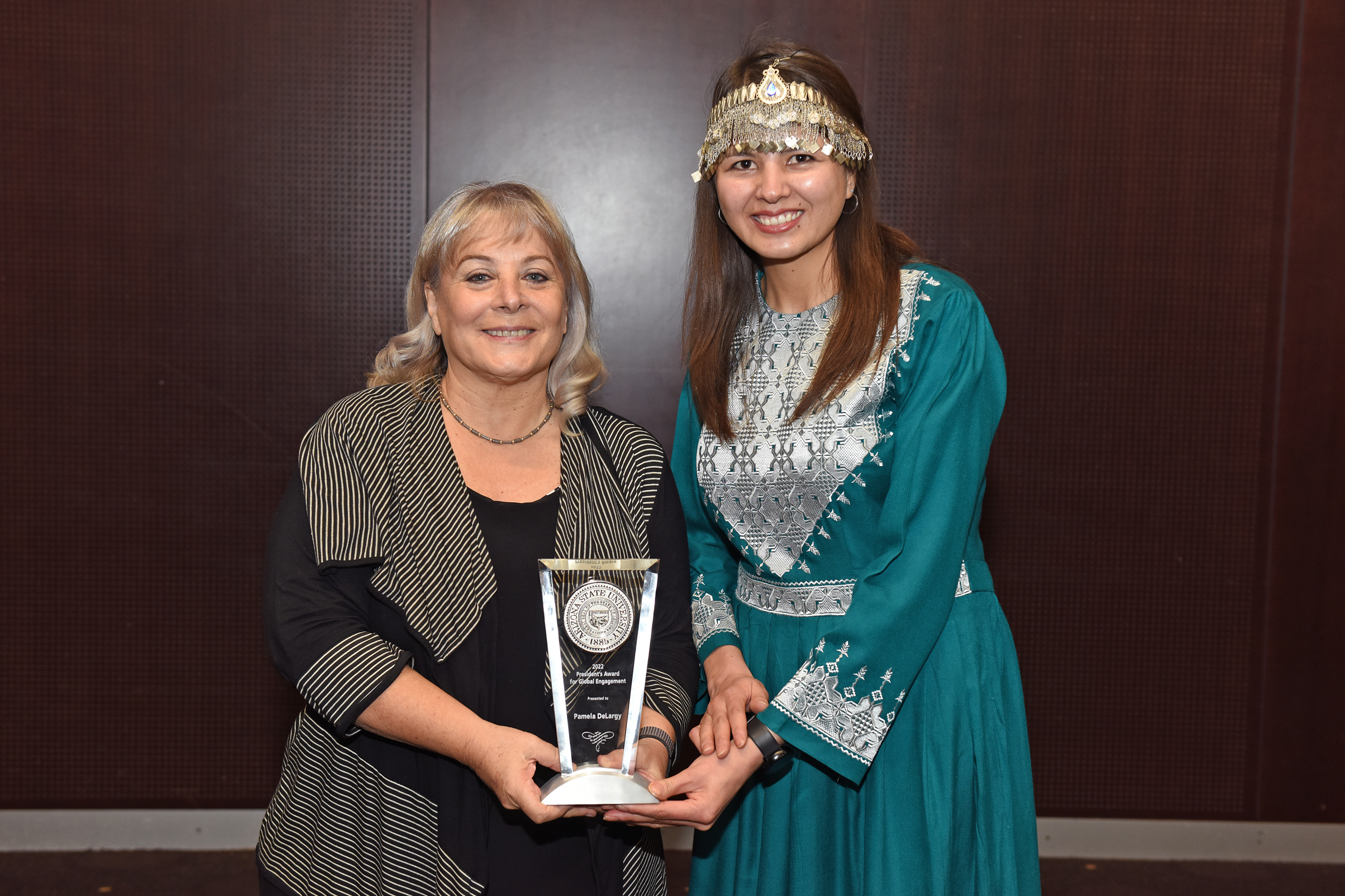 Woman holding award with student posing next to her