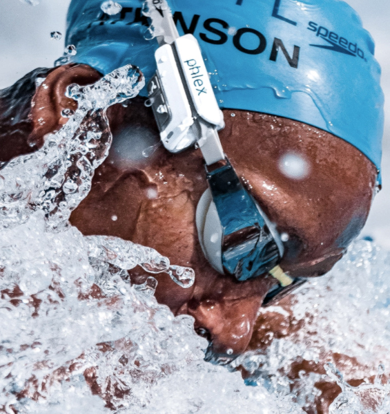 A swimmer swims wearing a cap and a device attached to their goggles