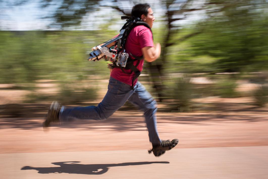 A student wears a jetpack while running.