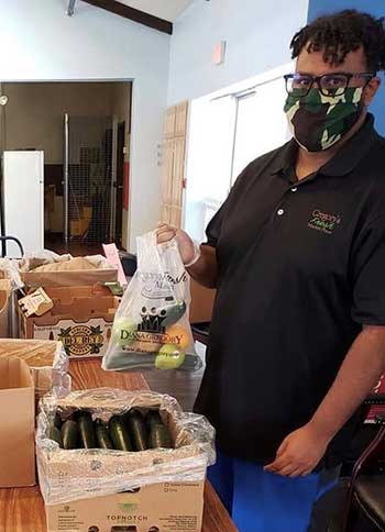 A man packs boxes of produce for vets and low income adults
