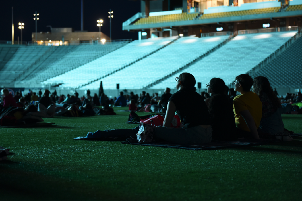Friends sit on a blanket at Movies on the Field