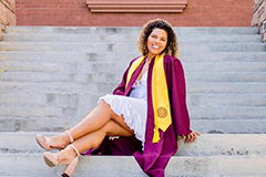 woman posing in graduation gown on Old Main steps