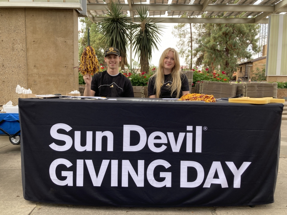 ASU Student Fundraisers Liam Barret and Cassidy Gross table in front of the Memorial Union for Sun Devil Giving Day